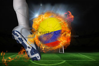 Football player kicking flaming colombia flag ball