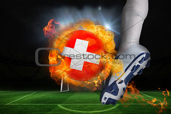 Football player kicking flaming swiss flag ball