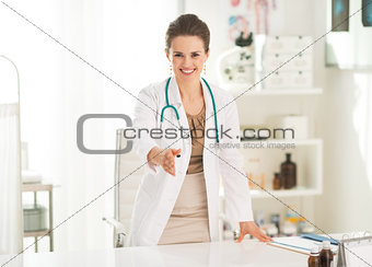Smiling medical doctor woman in office stretching hand for hands