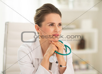 Portrait of thoughtful medical doctor woman sitting in office