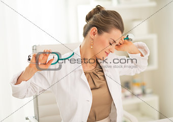 Tired medical doctor woman sitting in office