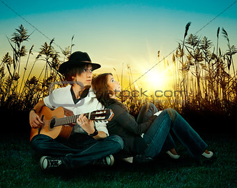 Love story. A young man playing guitar for his girl.