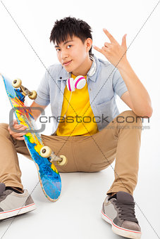skateboard man sitting and make a rock gesture 