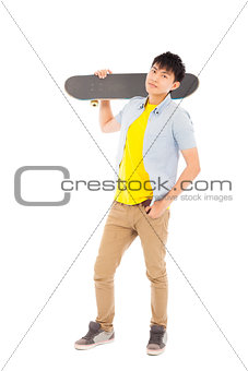 confident young man standing and holding a skateboard 