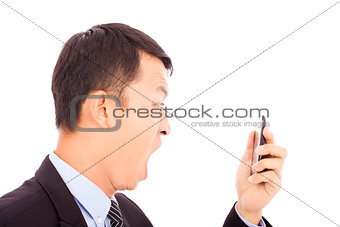 businessman screaming  into  smart phone over white background