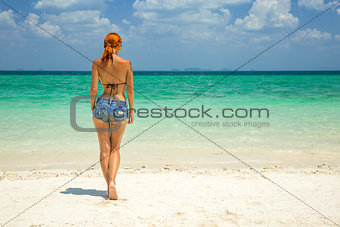 Beautiful redhead woman on the tropical beach 