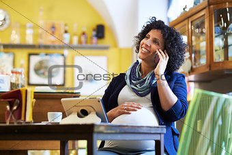 pregnant woman drinking espresso coffee in bar