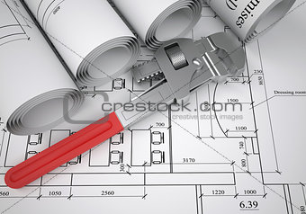 Scrolls of architectural drawings and pipe wrench