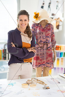 Portrait of smiling fashion designer in front of mannequin