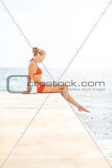 Young woman sitting on bridge