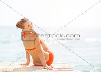 Happy young woman sitting on bridge