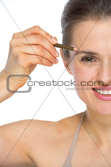 Closeup on young woman using eyebrows pencil