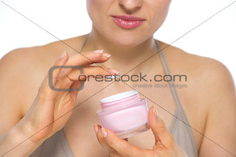 Closeup on young woman applying creme