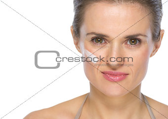 Portrait of young woman with creme on face