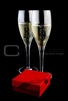 two glass with champagne near a gift