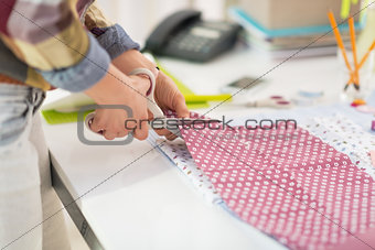 Closeup on seamstress cutting fabric