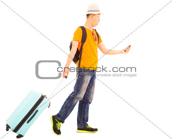 young backpacker carrying a baggage and holding a smartphone