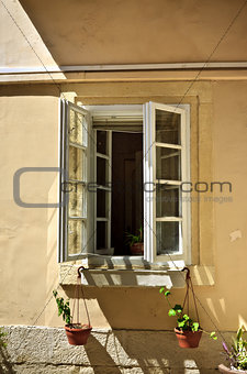 opened window with flowerpots