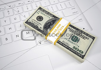 Bundle of dollar bills lying on computer keyboard