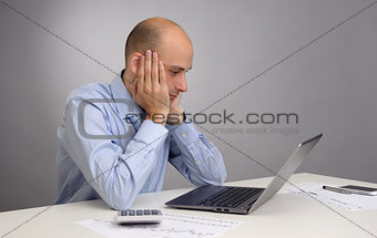 Tired businessman working with laptop in the office