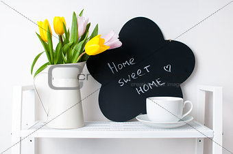 home interior decoration: a bouquet of tulips, a cup and  a chal