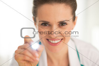 Medical doctor woman examining with flashlight
