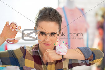 Portrait of confident seamstress with scissors and pincushion