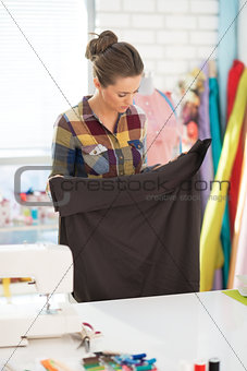 Seamstress looking on fabric in studio