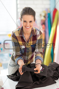 Happy seamstress showing fabric
