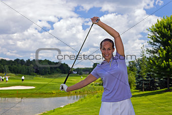 Female golfer stretching with a golf club