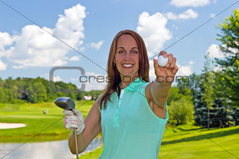 Woman with golf ball and club on the fairway