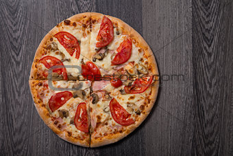 High angle view of delicious Italian pizza with ham and tomatoes