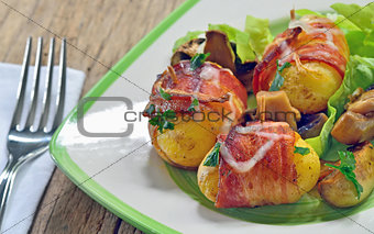 Baked potatoes wrapped in bacon