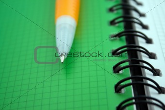 Orange ballpoint pen on notebook