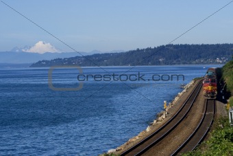 Train on Tracks Going By Pacific Ocean Mount Baker Background
