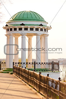 white gazebo with carved pillars on the waterfront 