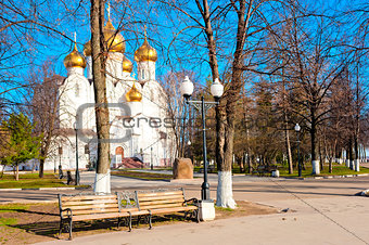 White church with golden domes in the park