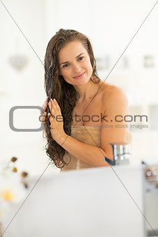 Portrait of happy young woman with wet hairs in bathroom