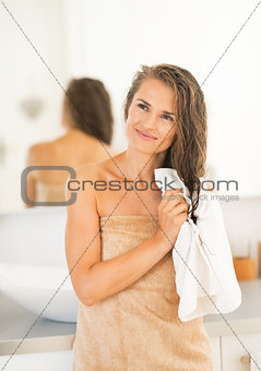 Portrait of happy young woman wiping hair with towel