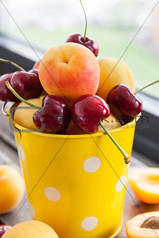 Fresh apricot and cherry in a bucket