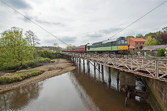English train on traveling on bridge over a river