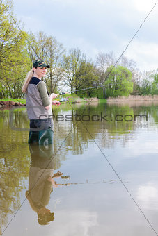 woman fishing in pond in spring