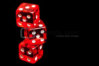 three red dice on black background