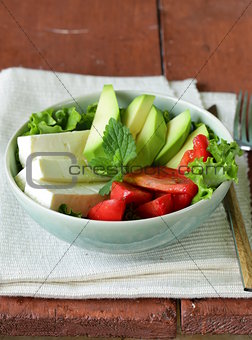 salad in asian style with tofu cheese, avocado and tomato