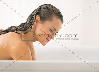 Young woman washing in bathtub