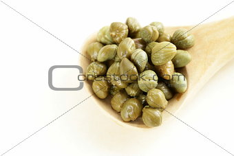 Pickled gourmet green capers in a wooden spoon