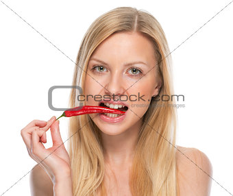 Portrait of teenager eating red chili pepper