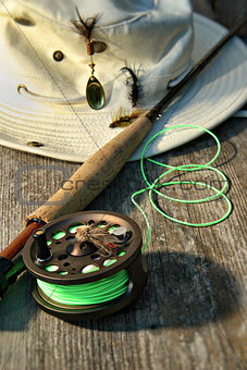 Close-up of fly-fishing reel and rod with hat