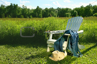 Jeans laying on adirondack chair in field