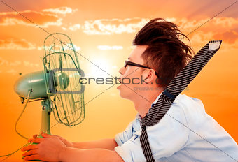 the heat wave is coming,business man holding a  electric fan